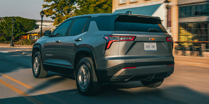 Gray Chevrolet Equinox SUV driving through a city street.