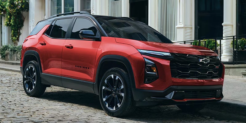 Red Chevrolet Equinox SUV parked outside a modern building.