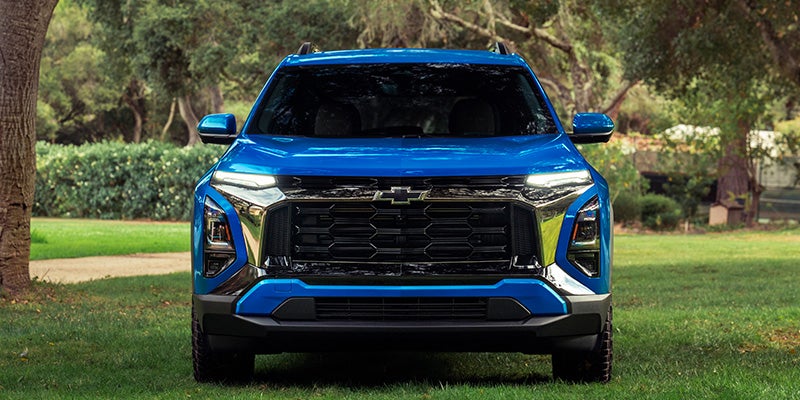 Blue Chevrolet Equinox SUV front view parked on a grassy outdoor setting.